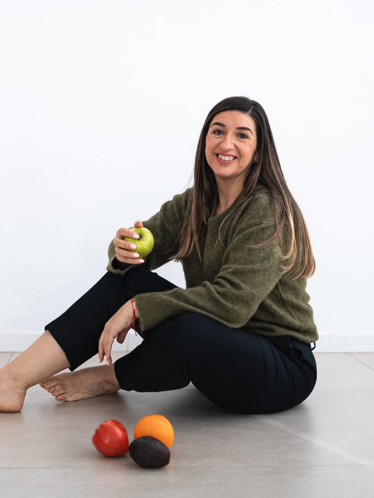 Dra. Vanessa Martín, doctora especializada en nutrición integrativa en Valencia, sentada junto a fruta fresca