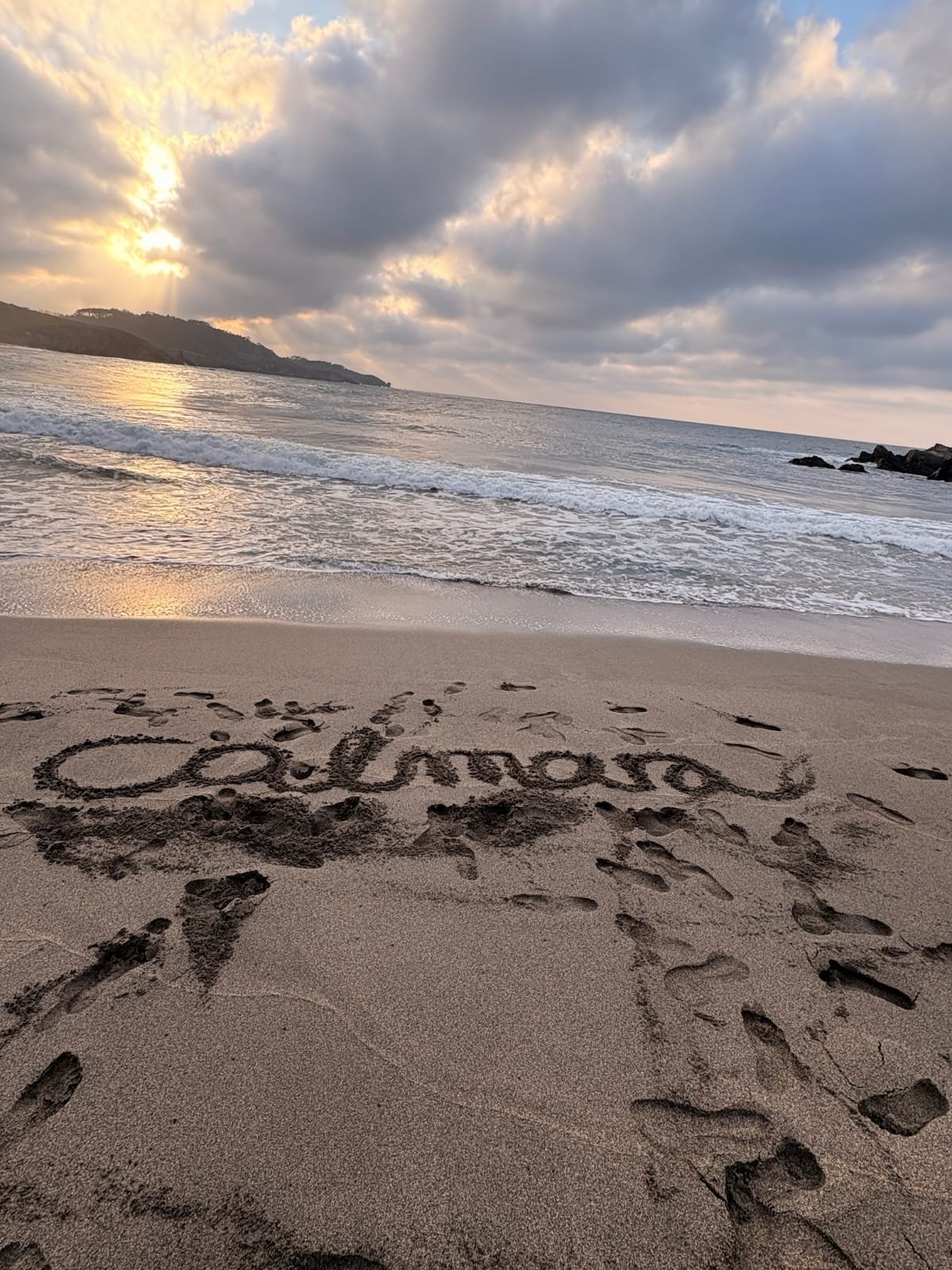 Calmara escrito sobre la arena de la playa